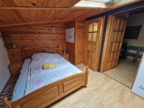 a bedroom with a bed in a wooden cabin at Apartament nad Jeziorem Necko in Augustów