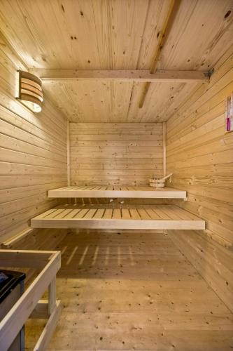 an empty sauna with wooden walls and wooden floors at Cozy Wooden House By The Lake in Falkensee