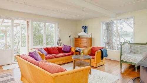 a living room with two couches and a table at Cabin On Private Island In Stockholms Archipelago in Mörkö