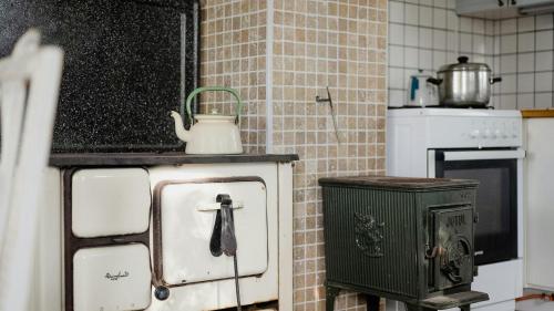 a kitchen with an old stove with a kettle on it at Cabin On Private Island In Stockholms Archipelago in Mörkö