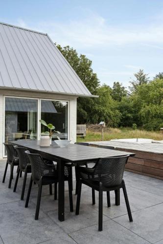 a black table and chairs on a patio at Fjord-Close Cottage With Beautiful View in Hemmet