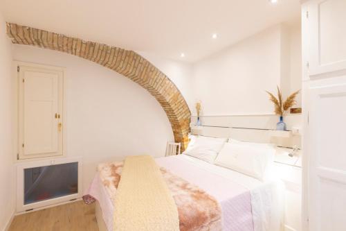 a bedroom with a white bed and a tv at Center Boutique in Cagliari