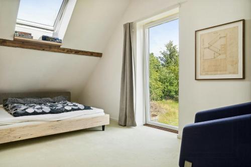 une chambre avec un lit et une grande fenêtre dans l'établissement Fjord-Close Cottage With Beautiful View, à Hemmet