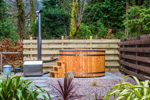 a wooden barrel sitting next to a wooden fence at Auchrannie Resort in Brodick
