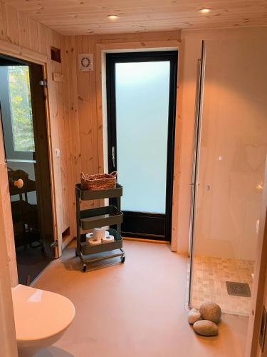 a bathroom with a shower and a glass door at Cozy Cabin At The Gateway To Jotunheimen in Vaga