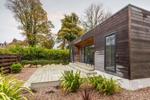 a small house with a wooden exterior at Auchrannie Resort in Brodick