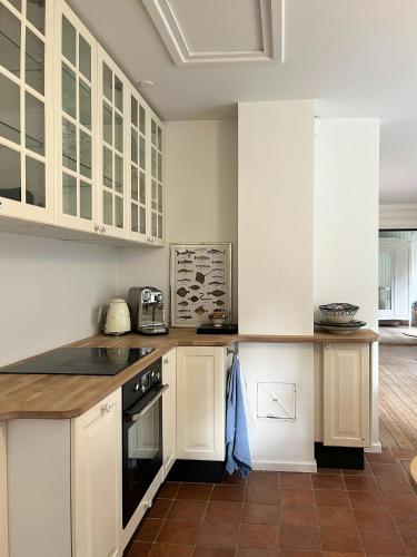 a kitchen with white cabinets and a counter top at Classic 30S House In Asserbos Woods in Frederiksværk