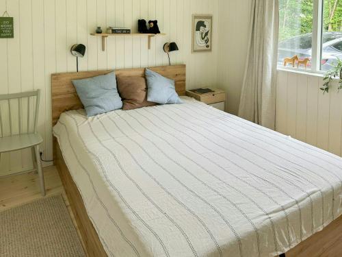 a bedroom with a large bed with blue pillows at Bright Home Near Brødemose Forest With Views in Frederiksværk