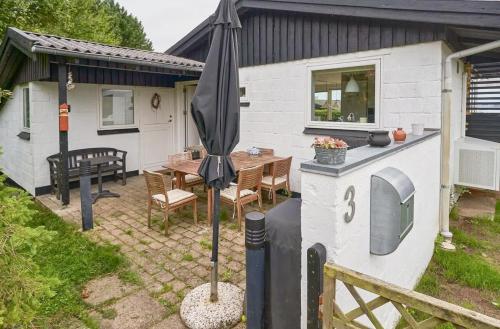 a patio with an umbrella in front of a house at Cozy Beach House With Sea View In Gråsten in Gråsten