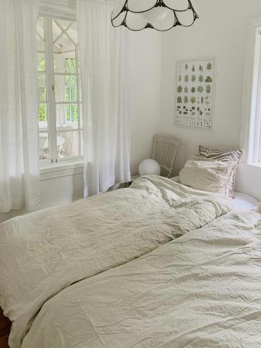a white bed in a bedroom with a window at Swiss-Style Villa With Forest Views Near Bråviken in Norrköping