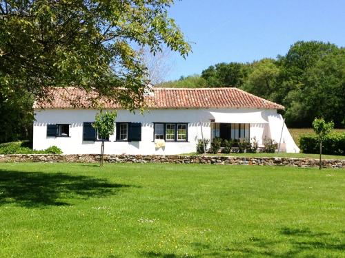 une maison blanche avec une pelouse devant elle dans l'établissement Basque Cottage With Views Of La Rhune Mountain, à Arcangues