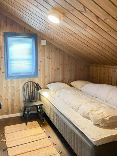 a room with two beds and a chair and a window at Fantastisk Familiehytte Nær Geilo in Geilo