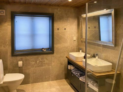 a bathroom with a toilet and a sink and a mirror at Fantastisk Familiehytte Nær Geilo in Geilo