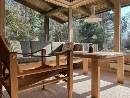 a porch with a couch and a table at Enjoy The Atmosphere In Wooden Summer House By The Bay in Højby