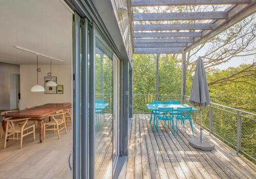 ein Haus mit einer Terrasse mit einem Tisch und Stühlen in der Unterkunft Renovated Chalet In The Heart Of Nature In Vendée in La Gaubretière