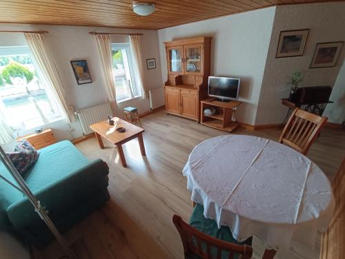 un salon avec une table et une télévision dans l'établissement Ferienwohnung Haarkotten, à Steinfurt