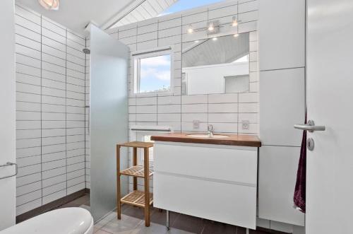 a white bathroom with a sink and a toilet at Cottage By Kolding Fjord With Panoramic View in Kolding