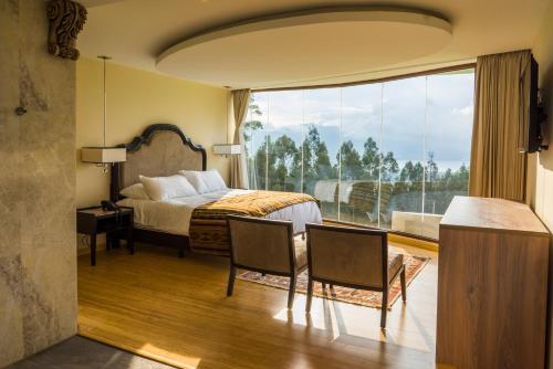 a hotel room with a bed and a large window at Hotel Medina Del Lago in Otavalo