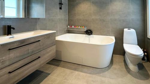 a bathroom with a tub and a toilet and a sink at Charming Farm From 1600S In Stunning Surroundings in Treungen