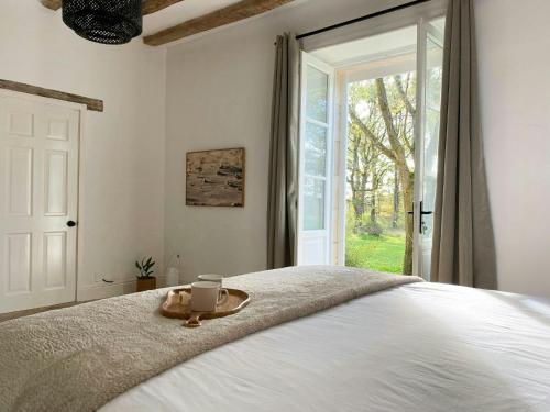 a bedroom with a bed with a tray with a candle on it at Peaceful Cottage Near Saint-Savin Abbey in Journet