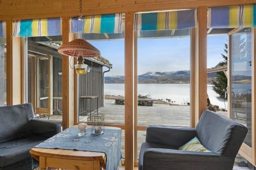 a living room with a view of the water at Seaside Cabin With Panoramic Views In Oterstranda in Inndyr