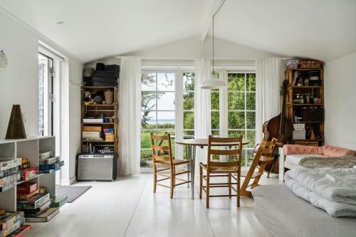 a living room with a table and chairs at Island Life Gem With All Heart Desires in Kragenæs