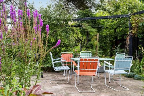 a table and chairs in a garden with purple flowers at Island Life Gem With All Heart Desires in Kragenæs