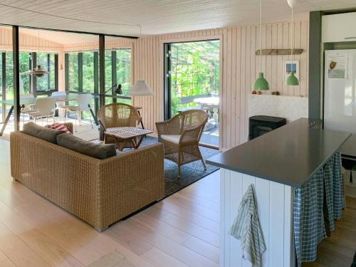 a kitchen and living room with a couch and a table at Forest Cabin With Panoramic View Near Blokhus in Blokhus