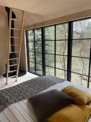 a bedroom with a bunk bed and a large window at Cozy Times In Log House Amongst Trees in Ebeltoft