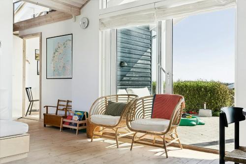 a living room with two chairs and a window at Cozy Home By Limfjord With Bathing Jetty in Snedsted