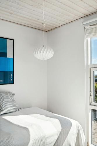 a white bedroom with a bed and a window at Cozy Home By Limfjord With Bathing Jetty in Snedsted