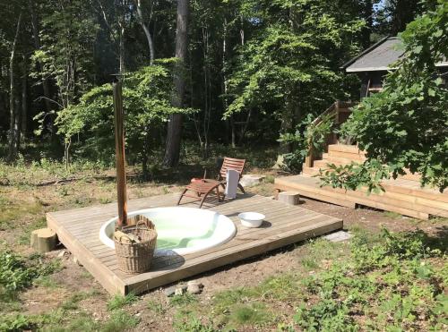 a bath tub sitting on a wooden deck in a yard at Charming Summerhouse In Korshage's Wild Nature in Rørvig