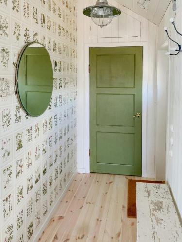 a green door in a white room with a mirror at Island House On Private Island With Sea View in Östhammar