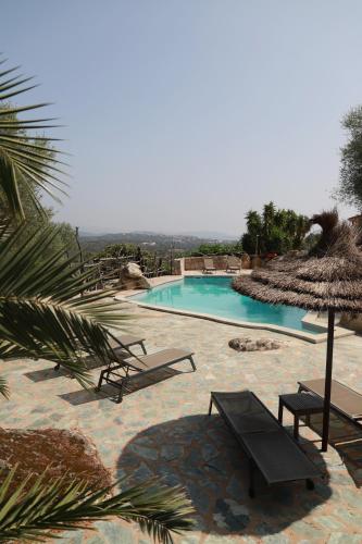 une piscine avec deux chaises et un parasol dans l'établissement Chalet en Corse du Sud, à Porto-Vecchio