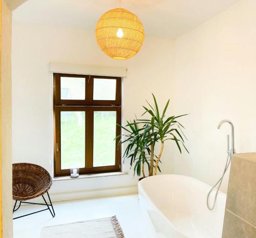 a bathroom with a white tub and a window at Spacious Country House With Idyllic Orchard in Schönwalde
