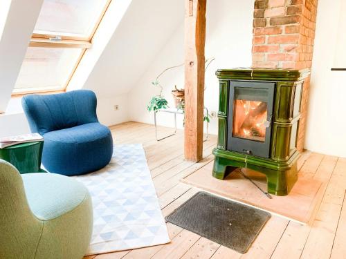a living room with a fireplace and a blue chair at Spacious Country House With Idyllic Orchard in Schönwalde