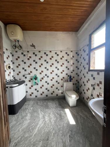 a bathroom with a toilet and a sink and a tub at Madhuchuli Homestay in Darjeeling