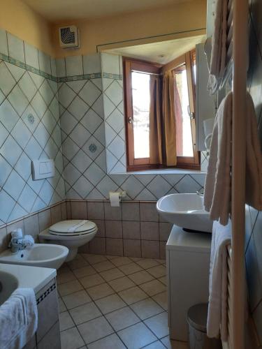 a bathroom with two sinks and a toilet and a window at Chalet La Rugiada in Bormio