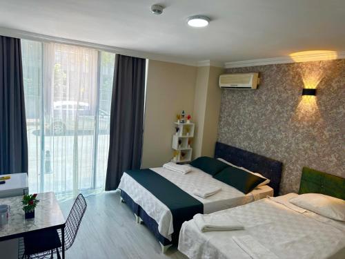 a hotel room with two beds and a window at Upart Flats by REFE in Antalya