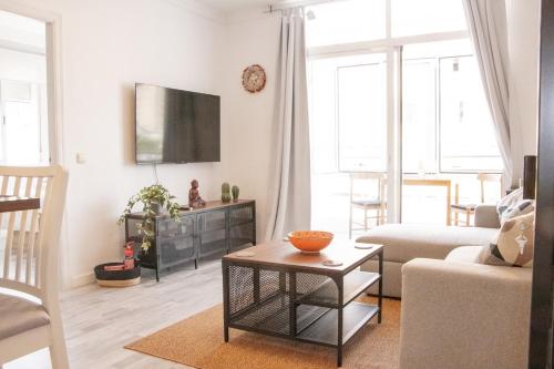 un soggiorno con un divano e una TV a parete di Amazonia City Center a Torremolinos