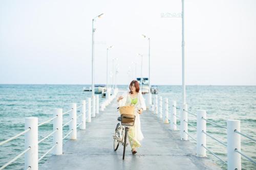 a woman riding a bike on a pier at Mafiya Resort in Koh Rong Island
