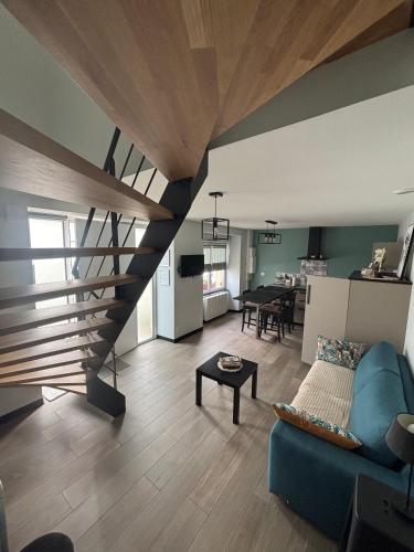 - un salon avec un canapé bleu et un escalier dans l'établissement Les Gîtes de la Frérie, à La Gaubretière
