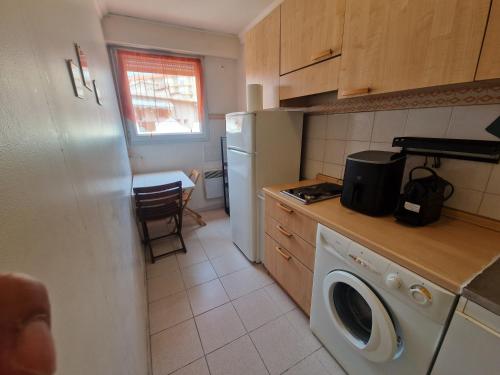 une cuisine avec un réfrigérateur et une machine à laver dans l'établissement Renoir SeaSide Apartment, à Nice