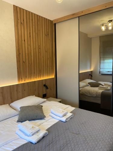 a bedroom with two towels on a bed with a mirror at Titova Vila - Golden Peak Residence in Zlatibor
