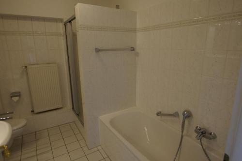une salle de bain blanche avec une baignoire et des toilettes dans l'établissement Lüttke Juwel, Ferienwohnung mit traumhaftem Seeblick, à Lembruch