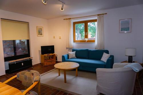 a living room with a blue couch and a table at Adele-gemütliche Erdgeschoss Ferienwohnung für 2-4 Personen in Hüde
