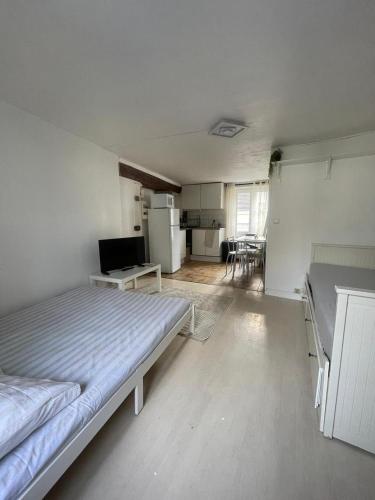 une chambre avec un grand lit et une cuisine dans l'établissement Studio Ecouen, à Écouen