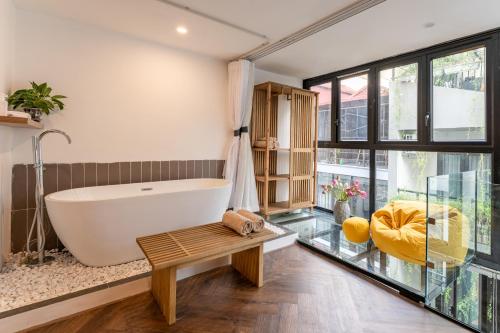 a bathroom with a tub and a bench and a table at Hanoian Hearths - 5 Bedrooms - Bath Tubs - Projectors in Hanoi
