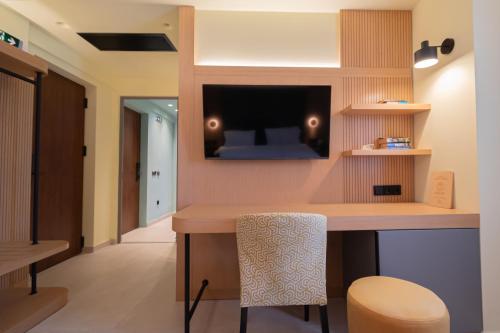 a room with a bar with a tv on the wall at Sokratis Hotel in Nea Moudania