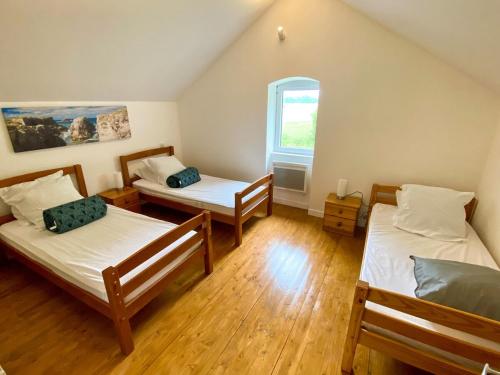 a room with three beds and a window at Charmante Maison au fil de la Voie Verte in Concarneau